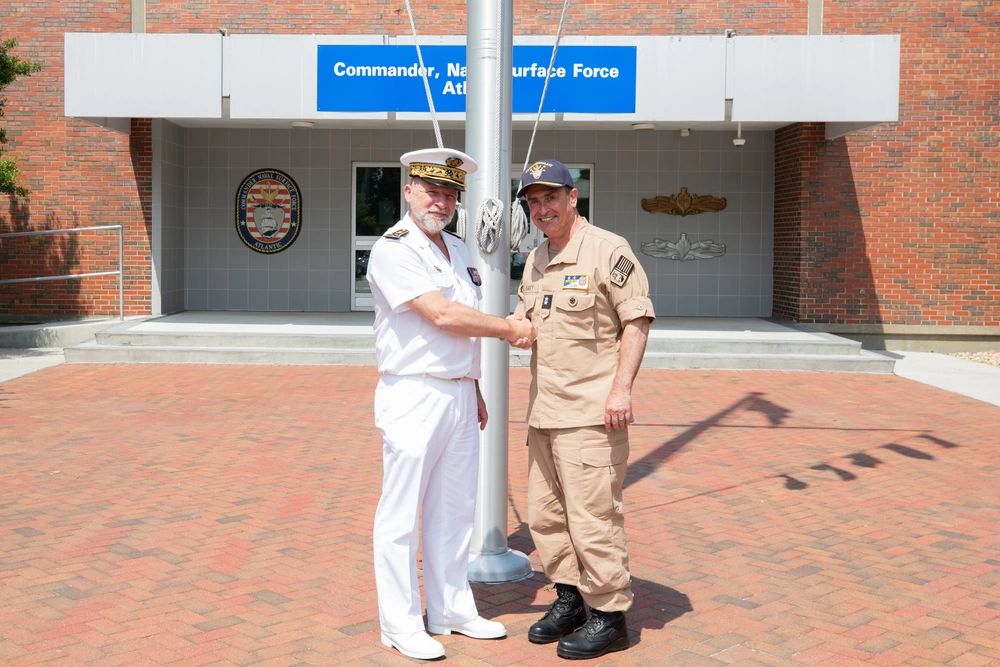 Almirante Christophe Cluzel, de uniforme branco, cumprimenta o contra-almirante americano Joseph Cahill em Norfolk
